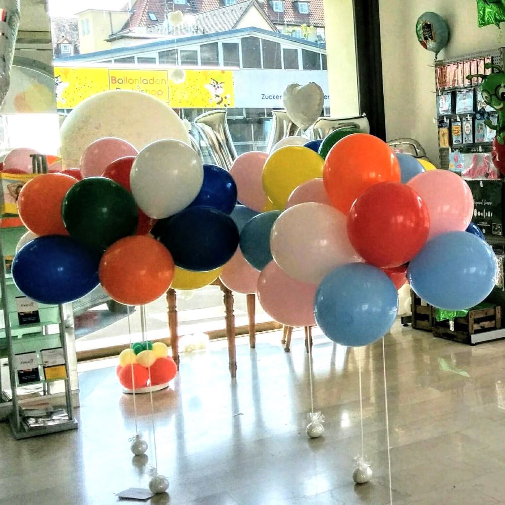 Bunte Latexballons in vielen Farben hängen unter einer Decke, alle mit Schnüren versehen-2