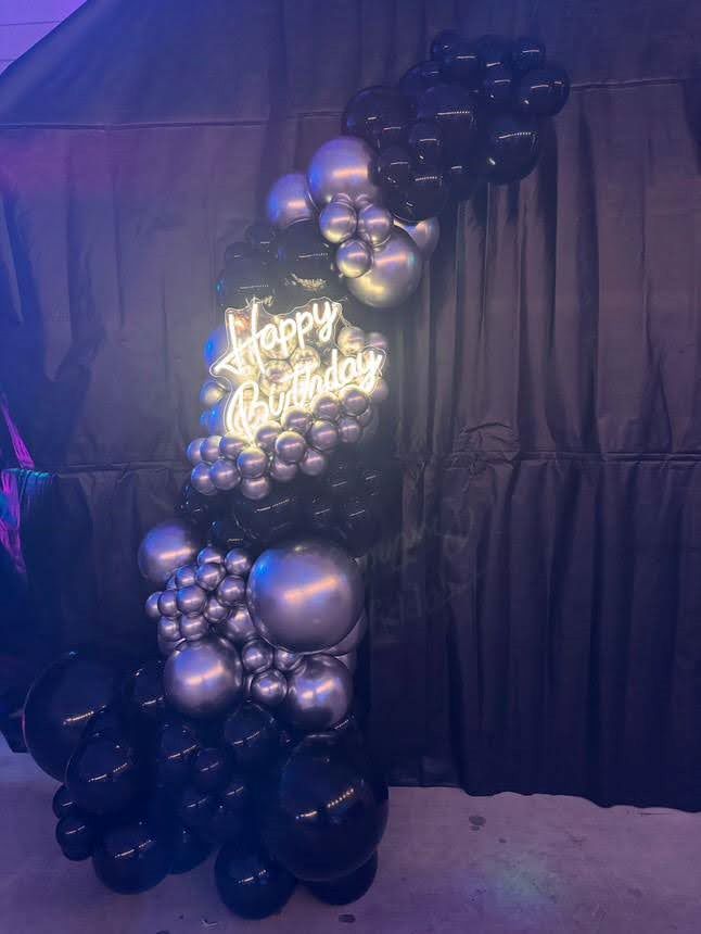 Halbkreisbogen aus schwarzen und silbern Ballons in verschiedenen Größen