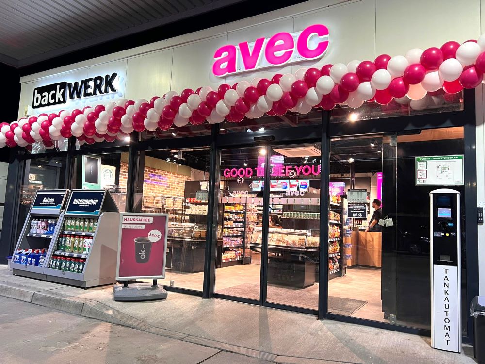 weiß-pinke Ballongirlande unter avec Schild über dem Ladeneingang