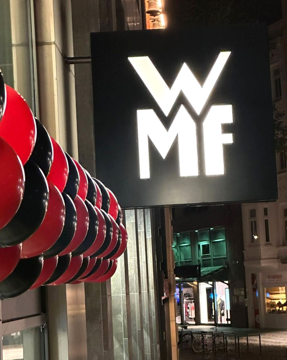 rot-schwarze Ballongirlande auf Hauswand angebracht neben WMF Schild
