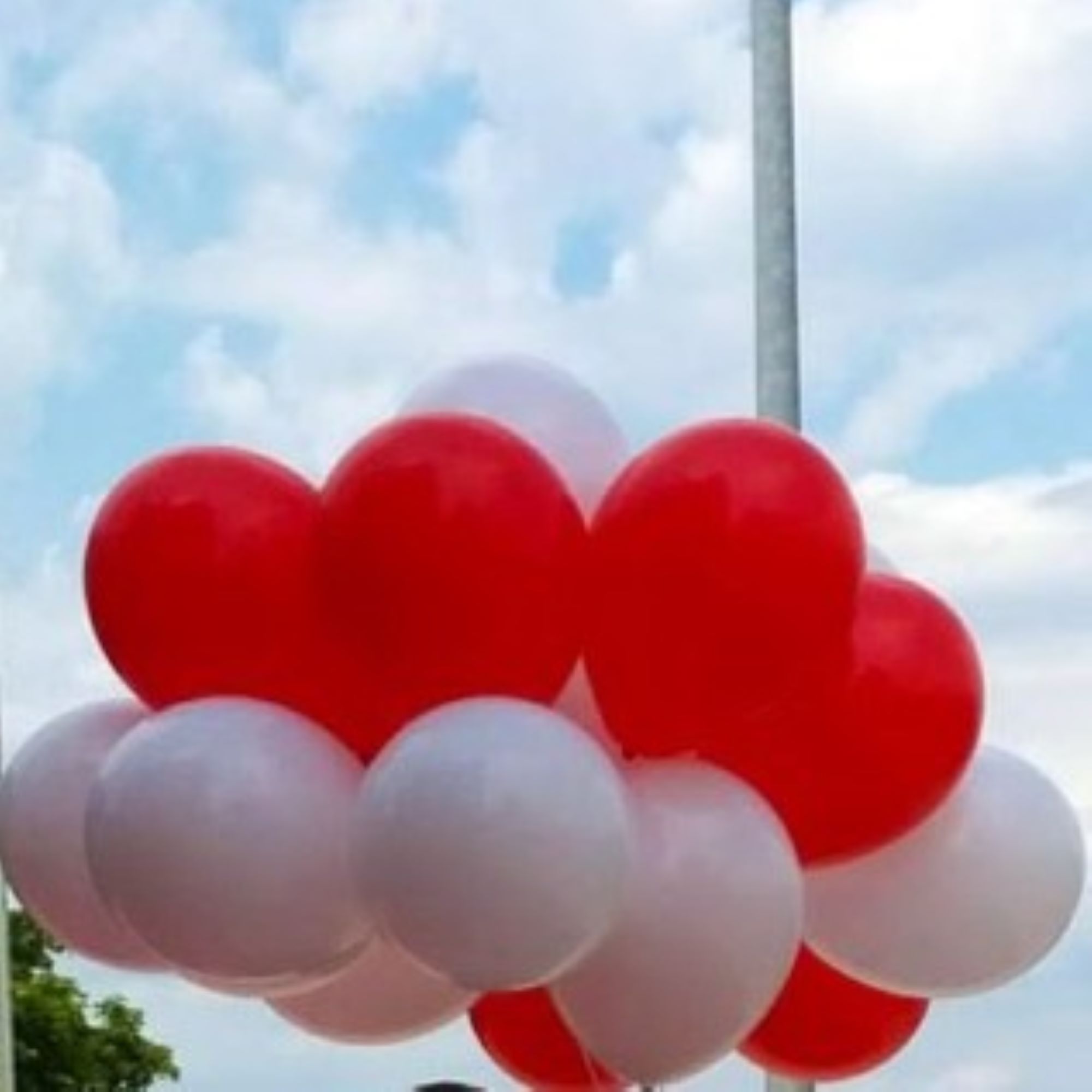 Konfetti-Bubble mit schwarzem Schriftzug „Congrats Anna“ und kleinem Graduierten-Hut, luftgefüllt auf einem silbernen Ballonfuß als Tischbouquet.
